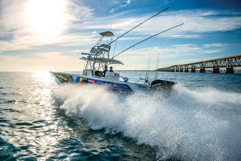 Center-console fishing boat running near bridge