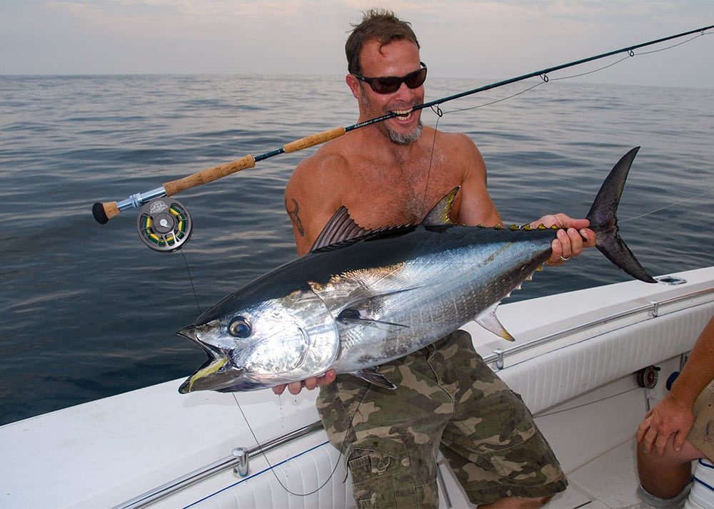 Fly fisherman holding tuna