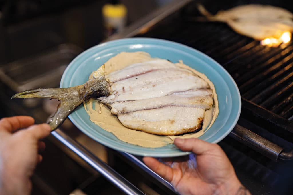 Hummus under the grilled pompano