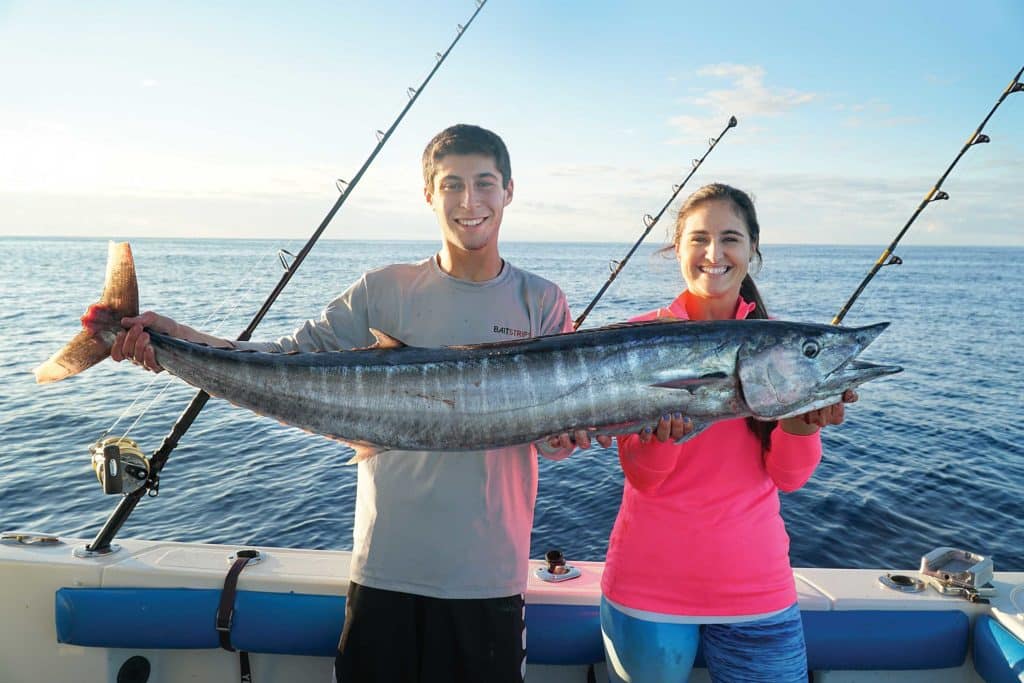 Holding up a freshly caught wahoo