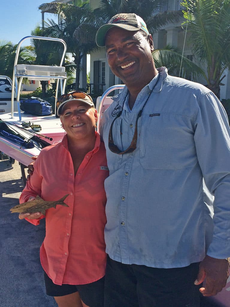 Mary Raulerson accepts a memento from Patrick Roberts, Blackfly Lodge guide that helped her connect with her first bonefish on fly.