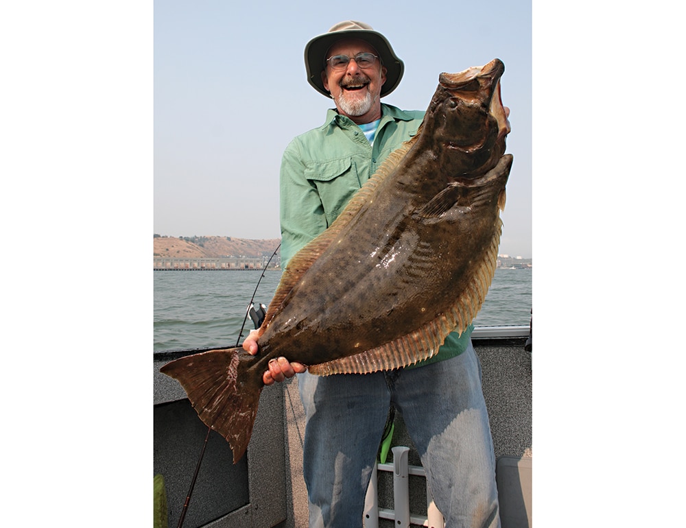 man holding up caught San Francisco halibut