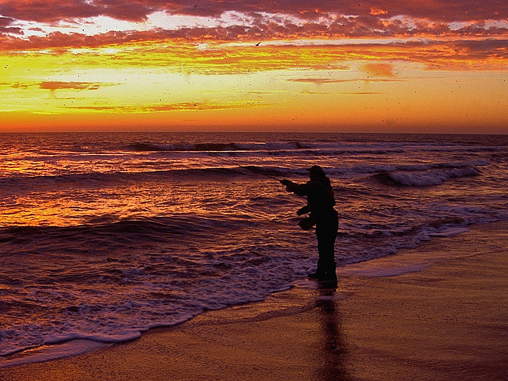 fly fishing from the beach at dawn