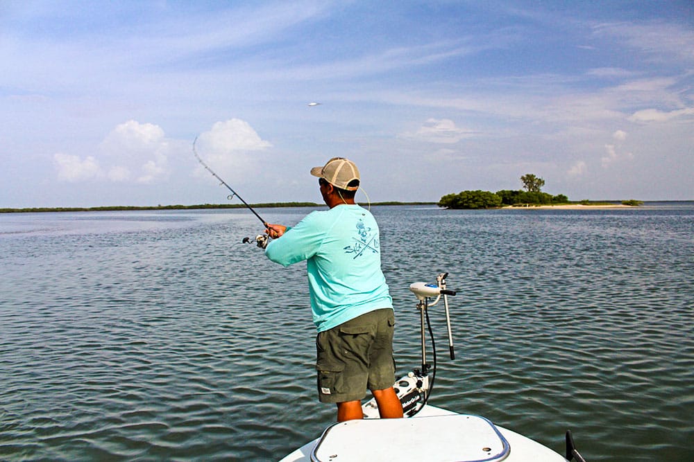 Flats angler casts a topwater lure to incoming fish.