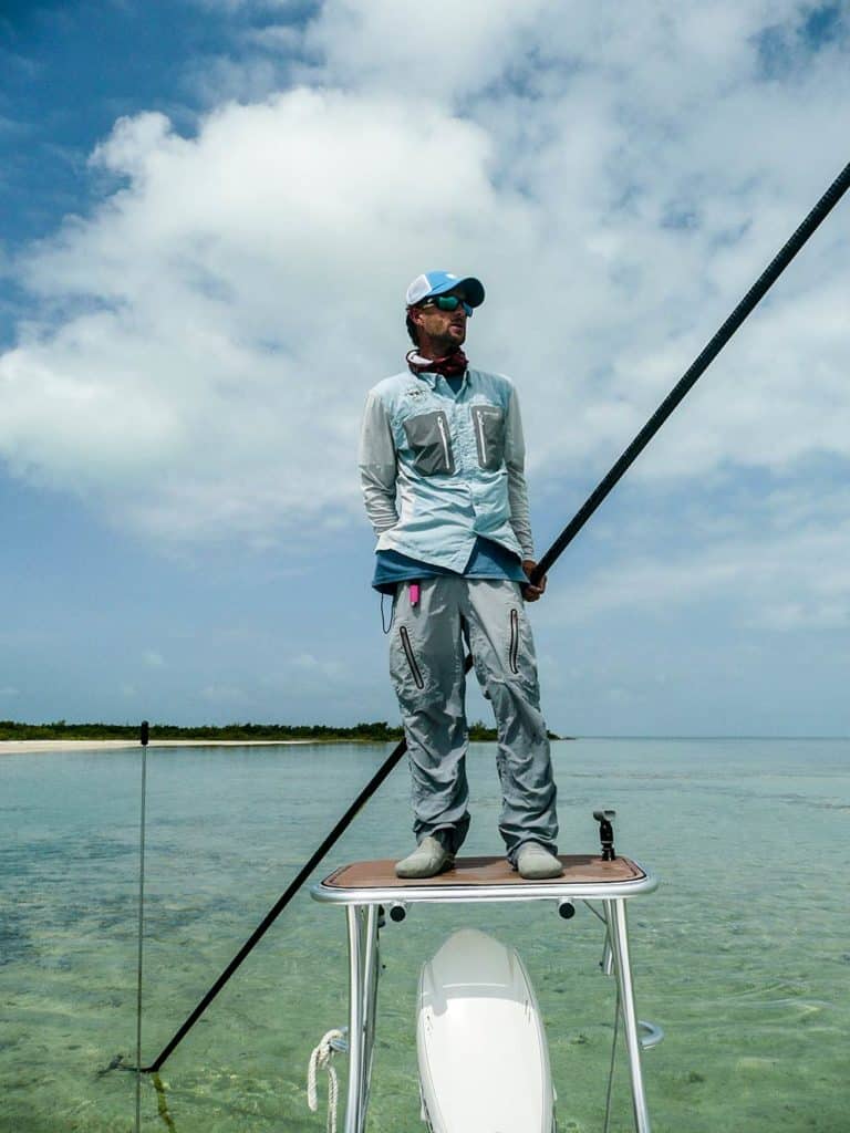 Flats guide looks for fish from atop the poling platform.