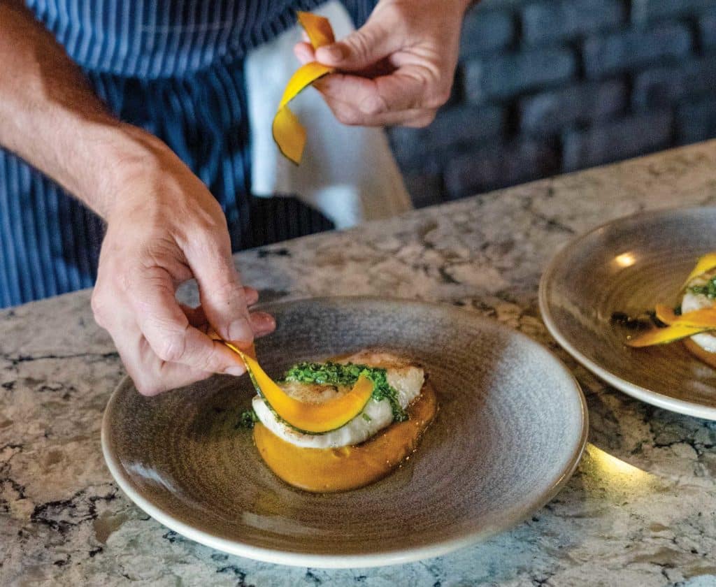 Plating grilled cobia with pickled squash and salsa verde