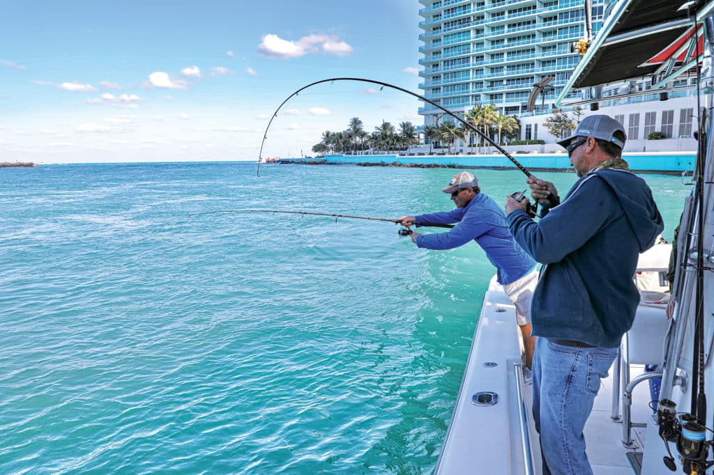 Two fishermen with a rod bent over