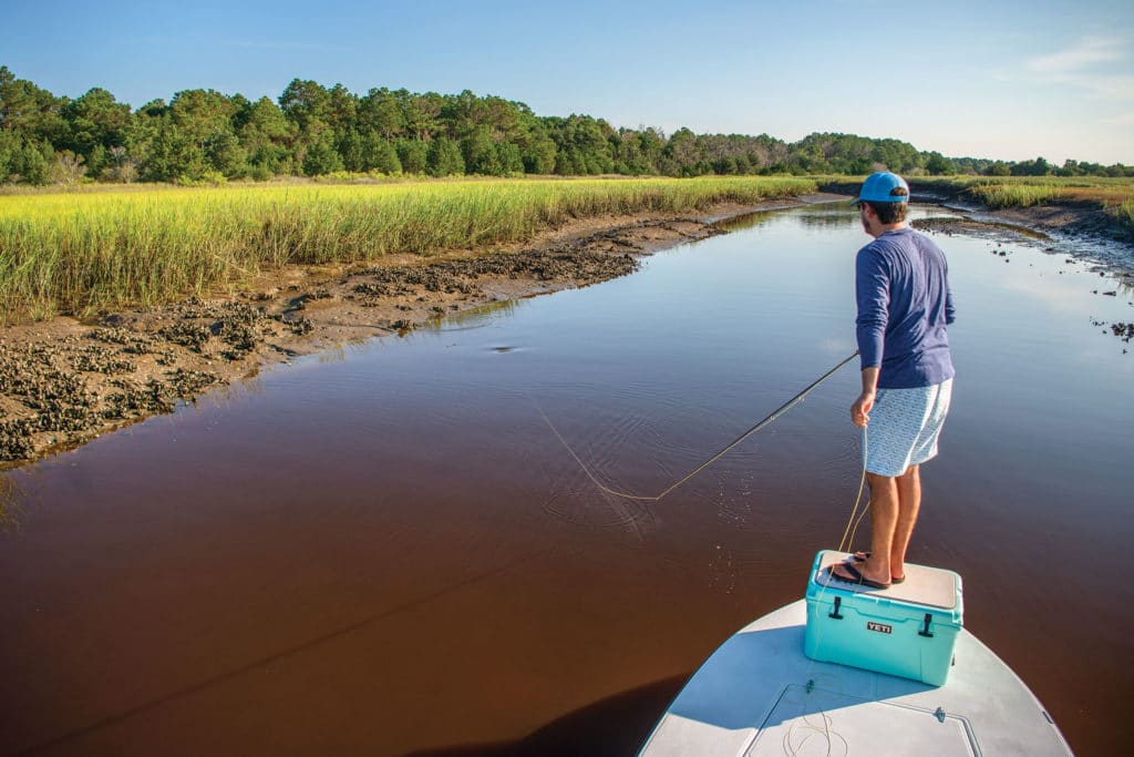 Angler standing on cooler and casting