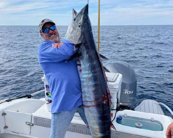 Fisherman holding up giant wahoo