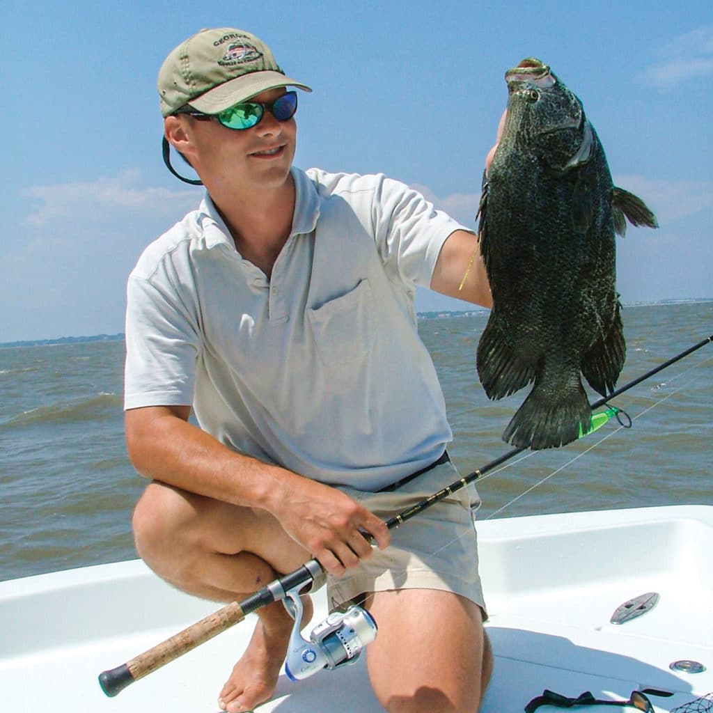 Tripletail held up on a boat