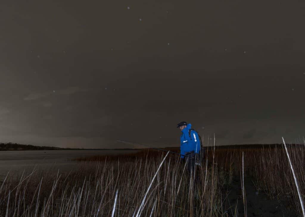 walking angler wearing Simms Splash Cast jacket