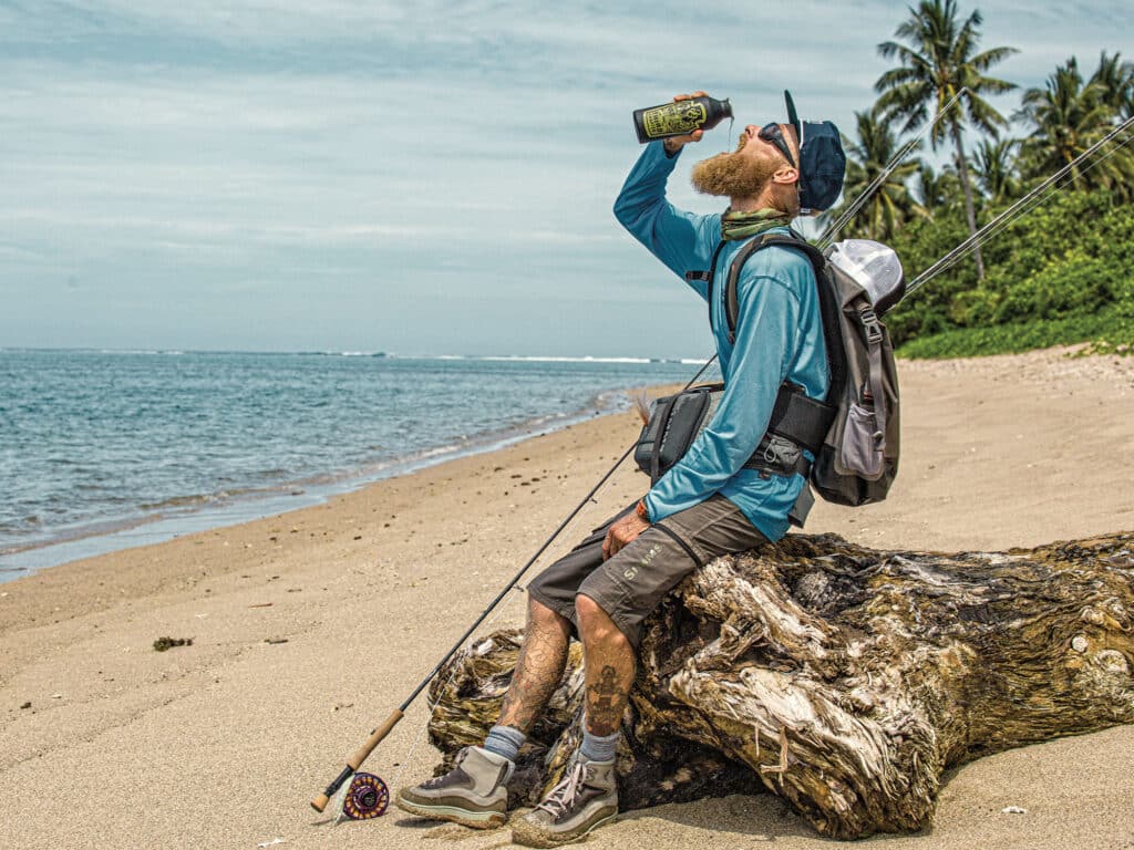 Angler on the beach drinking water