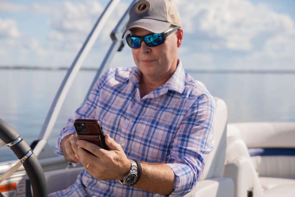 Angler looking at Siren Connected Boat mobile app