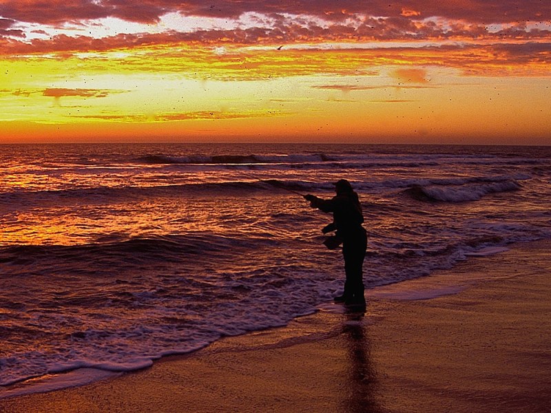 fly fishing from the beach at dawn