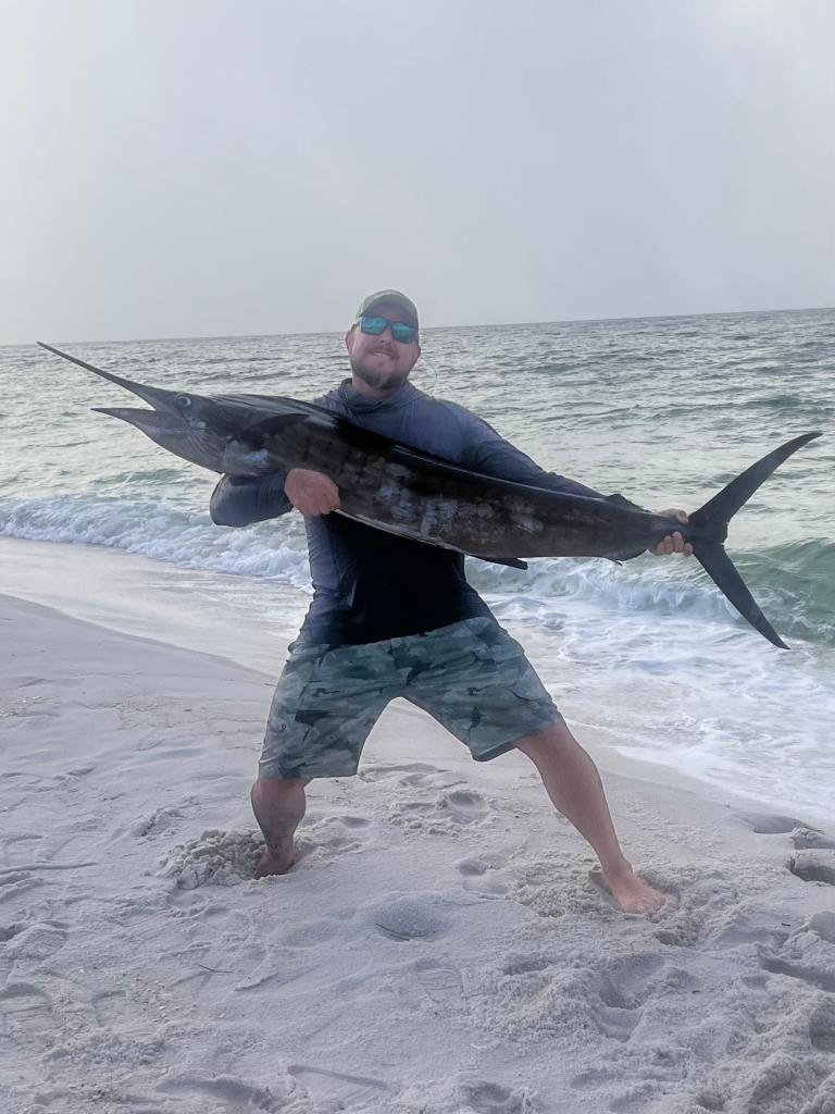 holding sailfish on beach holding sailfish on beach