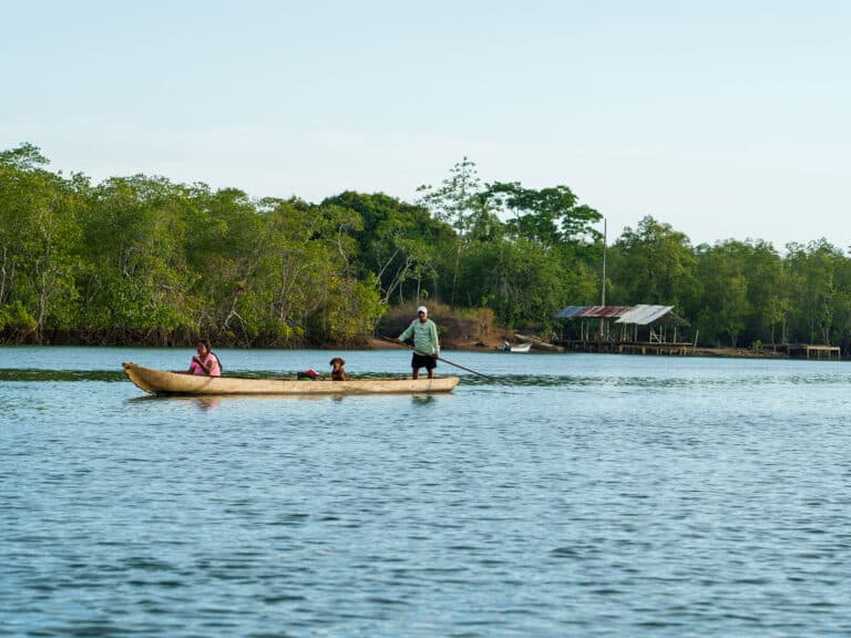 Villagers in dugout canoe