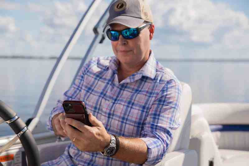 Angler looking at Siren Connected Boat mobile app