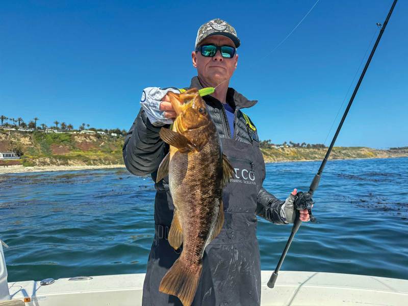 Angler holding calico bass on boat